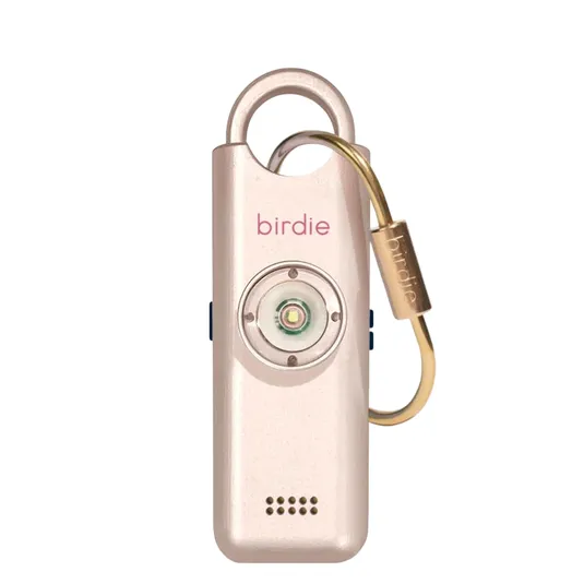 A gold-colored personal safety alarm with the word \“birdie\“ on it, featuring a loop for attachment, a prominent button, and a small speaker grill.