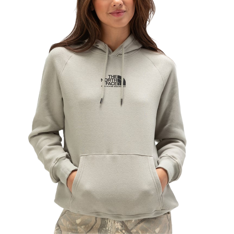 A woman is wearing a light gray The North Face hoodie with a front pocket. The hoodie features a small logo on the chest and has drawstrings on the hood.