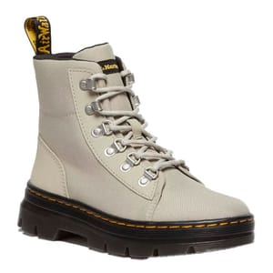 The Dr. Martens Combs Boots are sturdy, high-top lace-ups in beige canvas with metallic eyelets and a rugged black sole featuring signature yellow stitching and a branded pull tab.