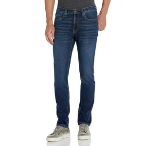 A person is wearing dark wash jeans with a slim fit, paired with a gray t-shirt and gray suede sneakers.