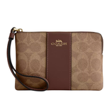 Tan and brown Coach wristlet with logo, featuring a zip closure and detachable wrist strap.