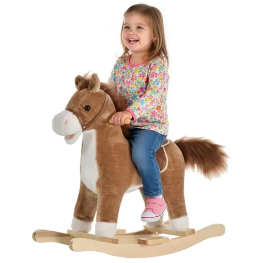 A child rides a plush rocking horse with a wooden base, wearing a colorful floral shirt, blue jeans, and pink sneakers.