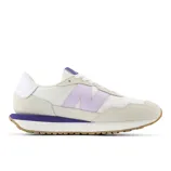 Cream and purple New Balance sneaker with a suede toe, gum sole, and the brand's signature \“N\“ logo on the side.