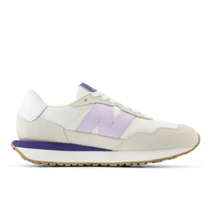 Cream and purple New Balance sneaker with a suede toe, gum sole, and the brand's signature \“N\“ logo on the side.