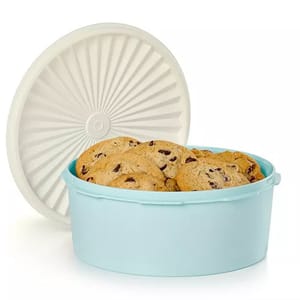 Tupperware Heritage Cookie Canister features a round, light blue container with a white, starburst-patterned lid, holding chocolate chip cookies.