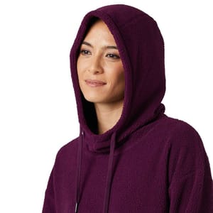 A woman wears a purple 32 Degrees Sherpa Hoodie featuring a soft, fleece texture with a hood, drawstrings, and a loose, comfortable fit.