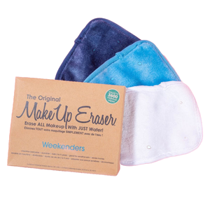 The 3-pack Makeup Eraser Weekenders Set includes three plush cloths in navy, light blue, and white, designed to remove makeup using only water. The package claims it is machine washable, suitable for sensitive skin, and eco-friendly.