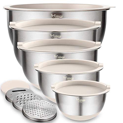 Four stainless steel mixing bowls with lids are stacked, paired with three grating attachments; all feature a brushed exterior finish.