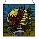 Stained glass panel depicting an eagle flying over a landscape with a sun and trees, featuring rich blues, greens, and browns.
