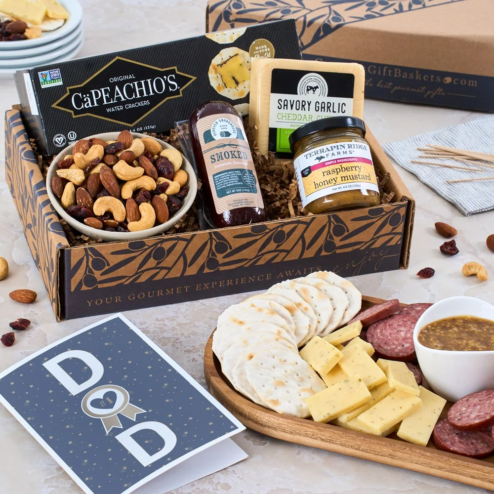 A gourmet gift basket featuring CaPeachio's water crackers, savory garlic cheddar cheese, smoked summer sausage, raspberry honey mustard, and a mix of nuts, accompanied by a \“Dad\“ card.