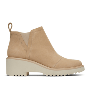 Beige suede wedge ankle boots with a pull tab, elastic side panels, and a lug sole for added traction and style.