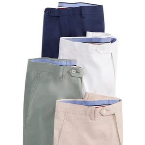 Four pairs of neatly folded pants in different colors: navy, white, green, and beige, each with a visible inner waistband lining.