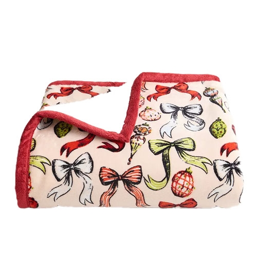 A soft blanket adorned with festive bows and ornaments, featuring a red trim and plush backing.