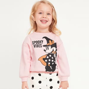 A pink sweatshirt featuring a graphic of Minnie Mouse in a black outfit with an orange bow and the text \“Spooky Vibes.\“ The sweatshirt has a crew neckline and long sleeves.