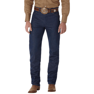 A person wearing dark blue jeans paired with a brown leather belt featuring an ornate buckle, brown cowboy boots, and a tan long-sleeve shirt.