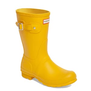 Yellow rubber rain boot with an adjustable buckle strap and a label on the front.