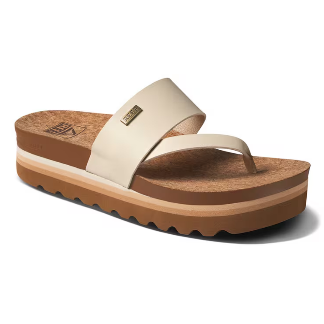 Beige sandal with a thick, contoured cork footbed, wide strap, toe post, and layered brown and white platform sole.