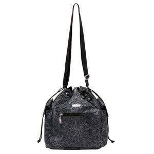 Baggallini Drawstring Crossbody is a black handbag with a floral pattern, featuring a drawstring closure, adjustable strap, and front zippered pocket.