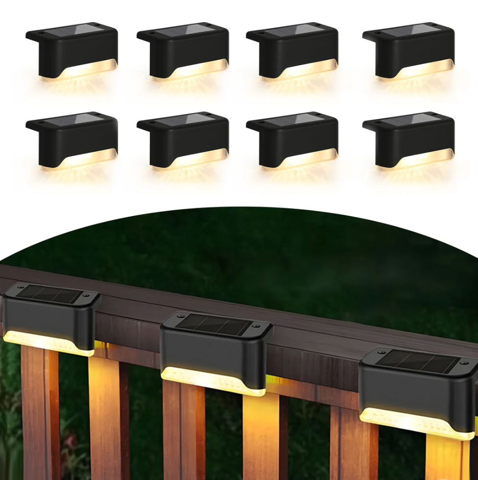 A set of black solar-powered LED deck lights designed for outdoor use is shown mounted on a wooden railing, providing warm downward lighting.