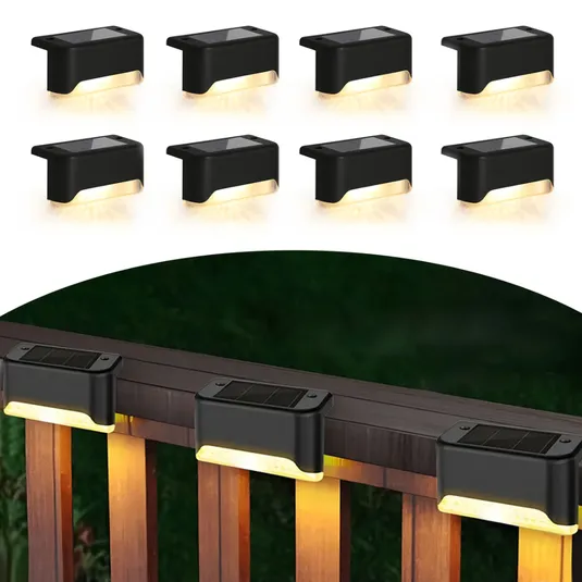 A set of black solar-powered LED deck lights designed for outdoor use is shown mounted on a wooden railing, providing warm downward lighting.