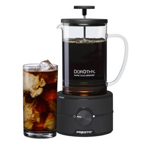 A Presto Dorothy Rapid Cold Brewer with a glass body and a black lid, featuring a handle and control knob, is shown beside a filled glass of iced coffee.