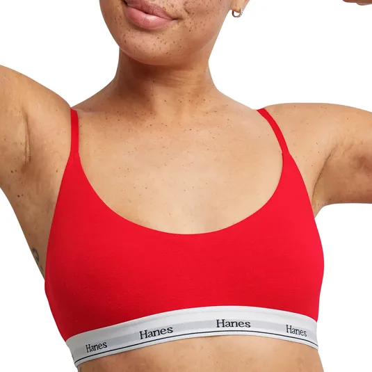 A person is wearing a red Hanes bralette with thin straps and a white band featuring the Hanes logo.