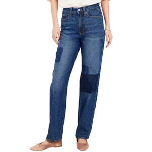 Blue jeans with a relaxed fit and patchwork details, paired with a white top and beige ballet flats.