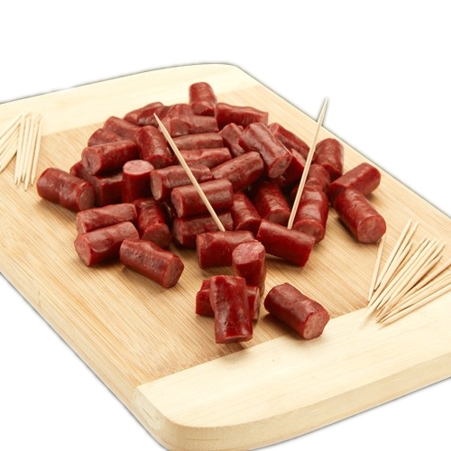 Chopped pieces of sausage arranged on a wooden board with toothpicks for serving.