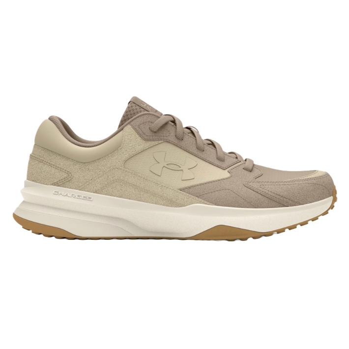 A beige and tan athletic shoe with a textured design, featuring a cushioned sole labeled \“Charged\“ and a logo on the side.