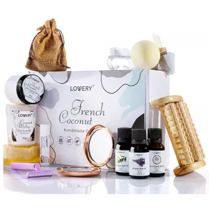 A spa gift set featuring a French Coconut theme includes a soy candle, lip balm, bath oils, a massager, pumice stone, bath bomb, soap, razor, compact mirror, and a small drawstring pouch.