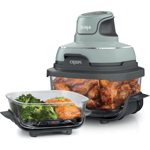 Ninja Crispi air fryer with cooked chicken wings inside and a separate container with broccoli and salmon.