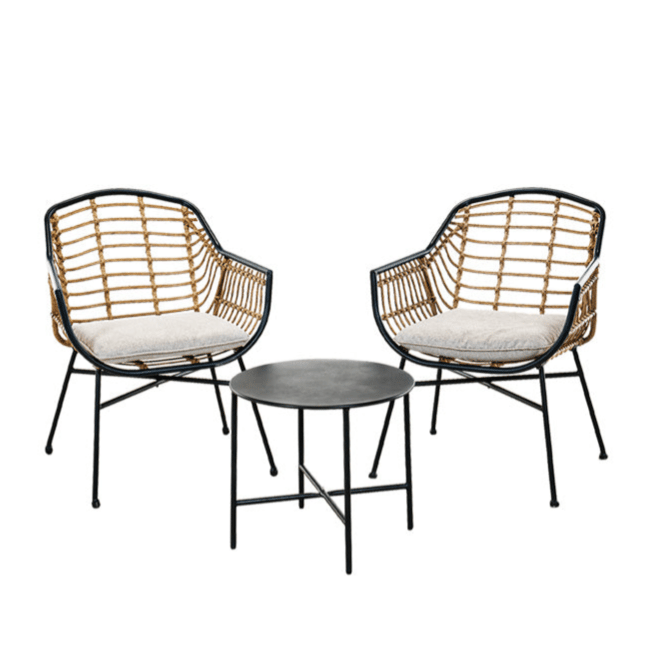 A bistro set featuring two wicker chairs with metal frames and cushions, paired with a round black metal side table.
