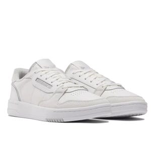 A pair of white Reebok sneakers with a classic low-top design, featuring a leather and suede upper, perforated toe box, and branding on the side.