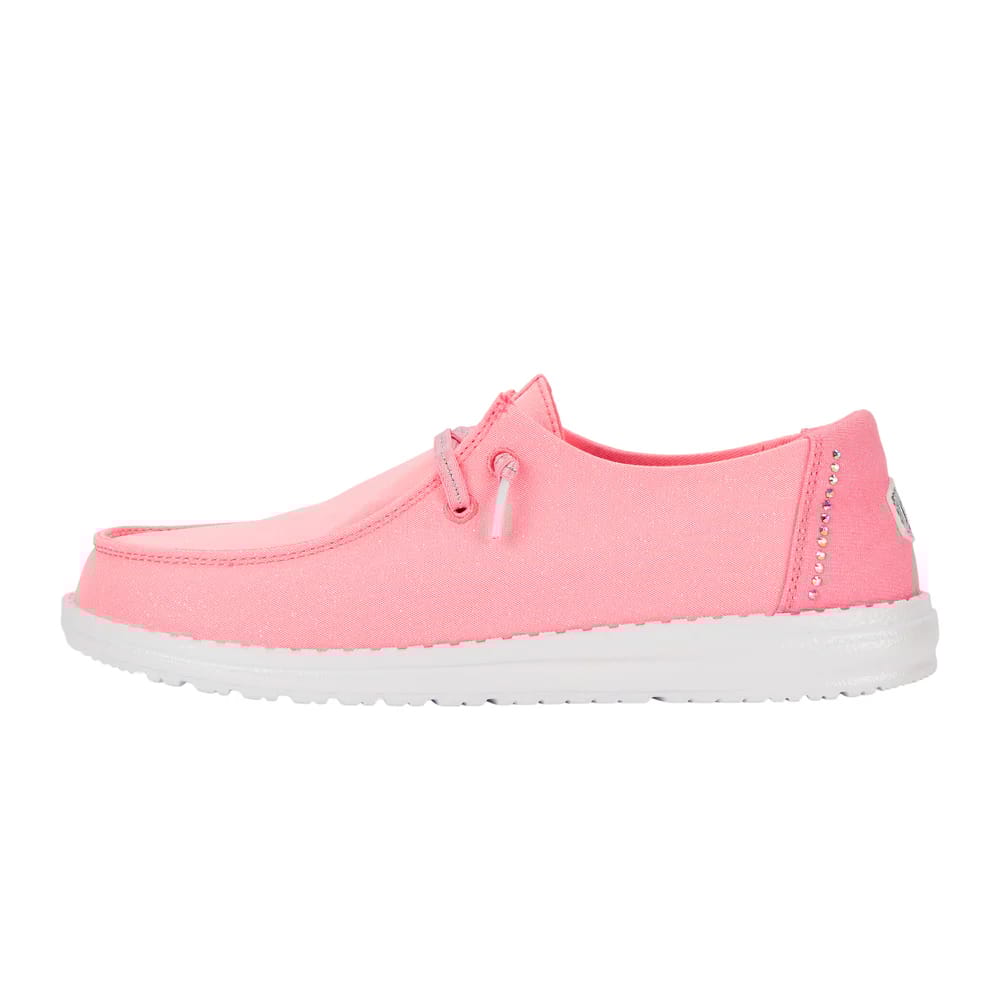 Hey Dude Wendy Stardust Shoes feature a vibrant pink color with a sparkly finish, a white sole, and decorative laces alongside rhinestone details on the heel.