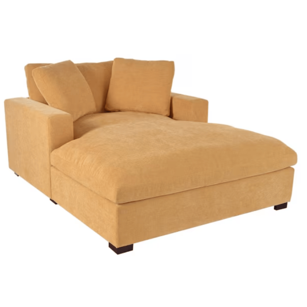 A large, mustard-yellow chaise lounge with plush cushions and dark wooden legs.