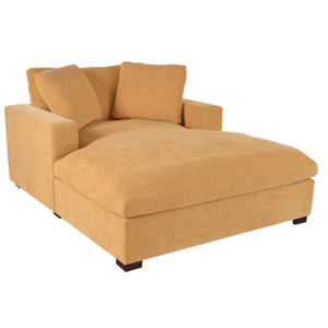 A large, mustard-yellow chaise lounge with plush cushions and dark wooden legs.