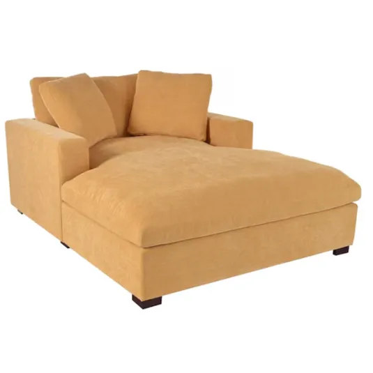 A large, mustard-yellow chaise lounge with plush cushions and dark wooden legs.