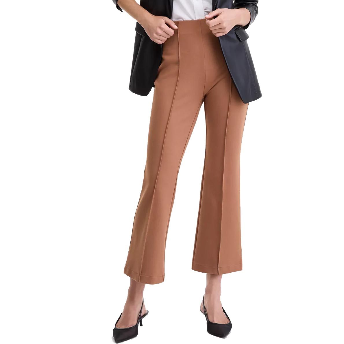 A person wears camel-colored flared pants paired with a black faux leather blazer, a white top, and black pointed-toe heels.
