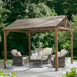 A wooden-frame gazebo with a peaked, metal hard-top roof, providing shade over a seating area that includes a sofa, two armchairs, and a coffee table. The setup is situated on a patio surrounded by greenery.