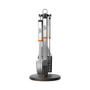 Stainless steel rotating grill tool stand with four tools: a basting brush, fork, spatula, and tongs, featuring orange accents and a circular base for easy access.