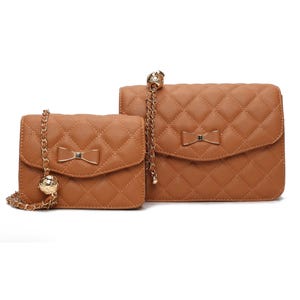 Two brown quilted handbags with chain straps, each adorned with a decorative bow and gold accents, are displayed side by side.