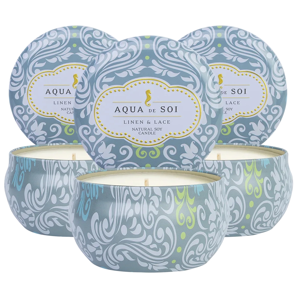 A set of three Aqua de Soi soy candles in decorative tins with a \“Linen & Lace\“ scent. Each tin features an ornate blue and white swirl pattern with a subtle touch of green.