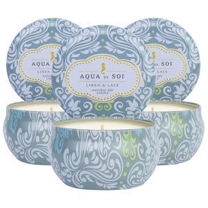 A set of three Aqua de Soi soy candles in decorative tins with a \“Linen & Lace\“ scent. Each tin features an ornate blue and white swirl pattern with a subtle touch of green.