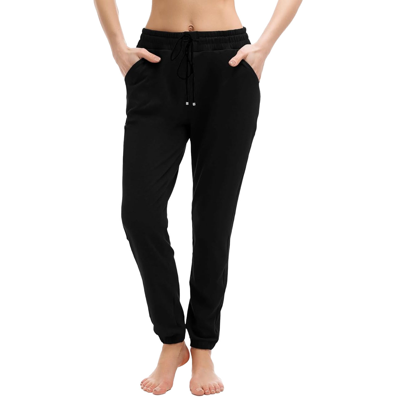 Black joggers with an elastic waistband, drawstring, and pockets, worn by a barefoot person.