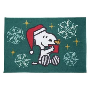 A festive doormat featuring a cartoon dog in a Santa hat, holding a gift with snowflakes and gold stars on a green background.