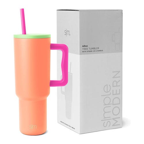 A coral-colored 40oz Simple Modern insulated tumbler with a pink handle and a green straw, next to its box.