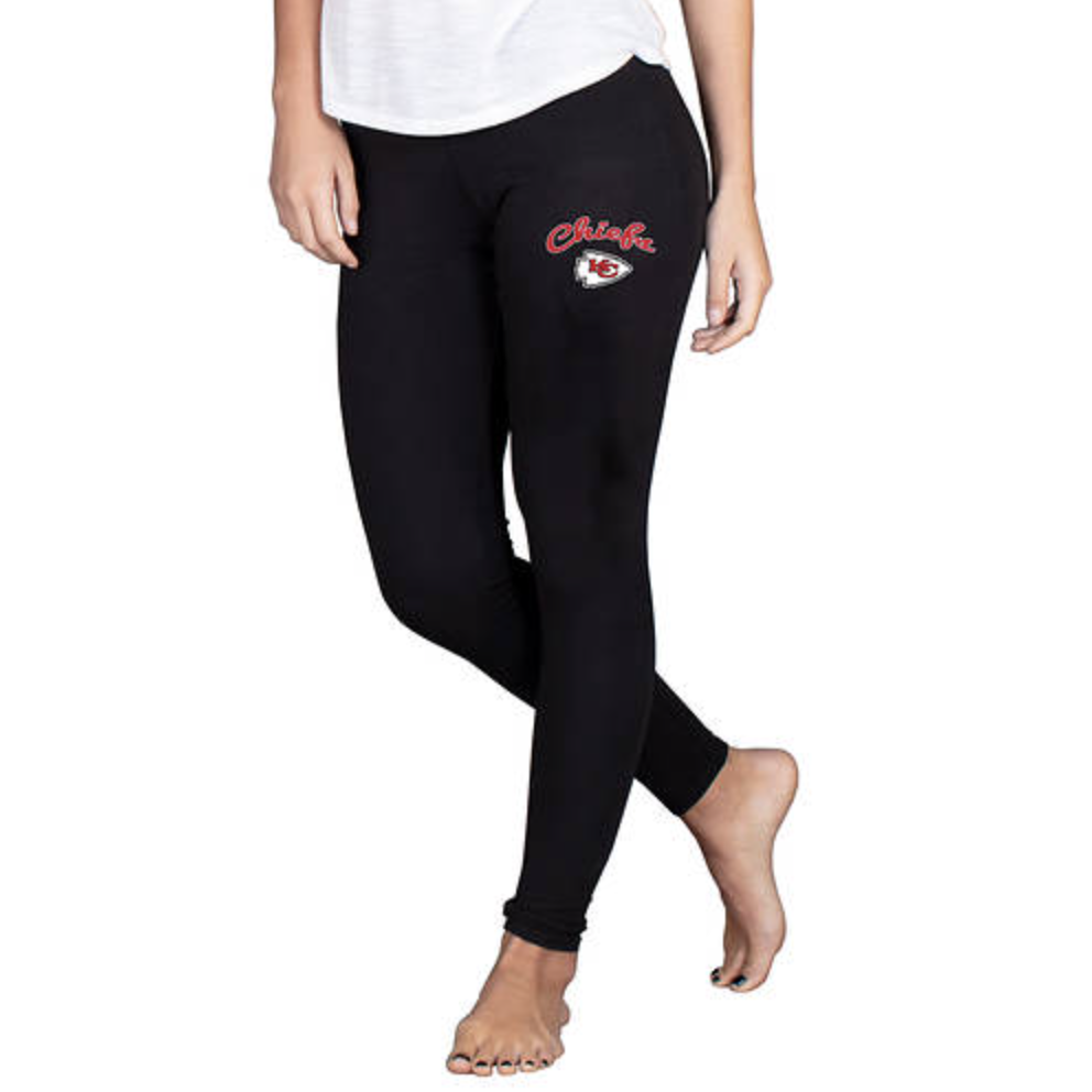 Black leggings featuring the Kansas City Chiefs logo and the word \“Chiefs\“ in red script on the upper right leg, worn by a barefoot person in a white top.
