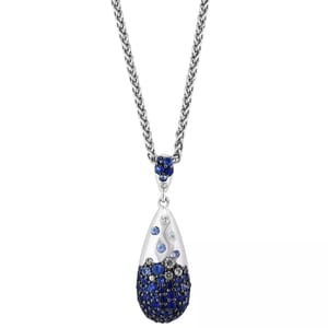 A silver necklace features a teardrop-shaped pendant adorned with blue and clear crystals, suspended from a silver chain.