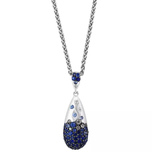 A silver necklace features a teardrop-shaped pendant adorned with blue and clear crystals, suspended from a silver chain.
