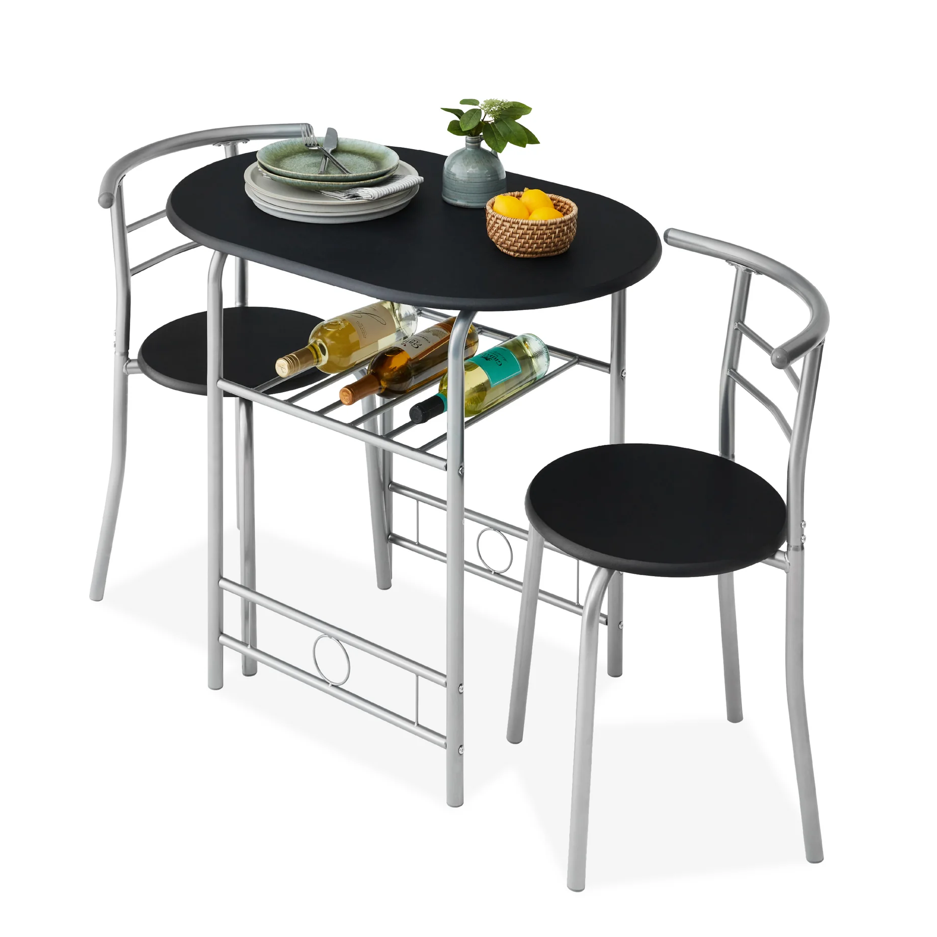 Compact dining set with a black oval table and two chairs featuring silver metal frames. Includes underneath rack storing wine bottles and tabletop decor with a plant and fruit basket. Perfect for small spaces.